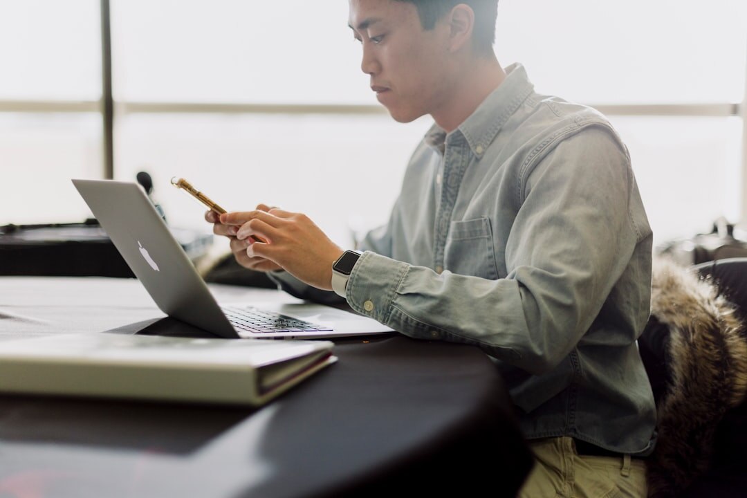 Journalist writing a story on a laptop in a newsroom