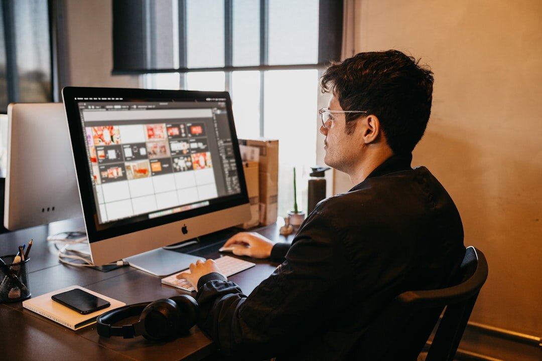 News editor working at a desk with multiple monitors showing news content
